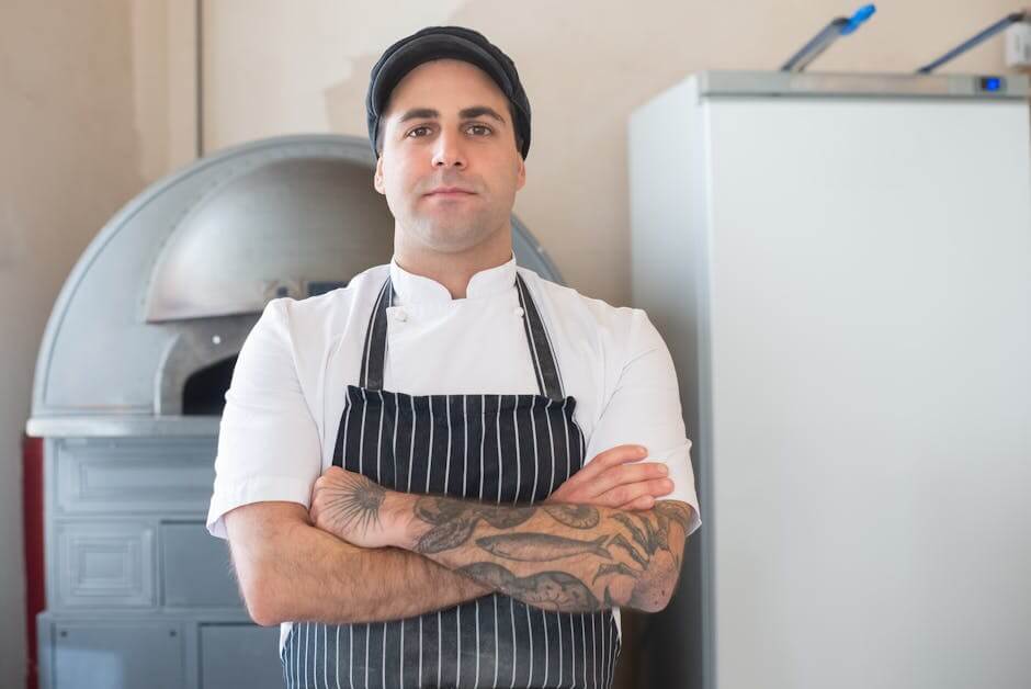 Confident chef with crossed arms in a kitchen setting.