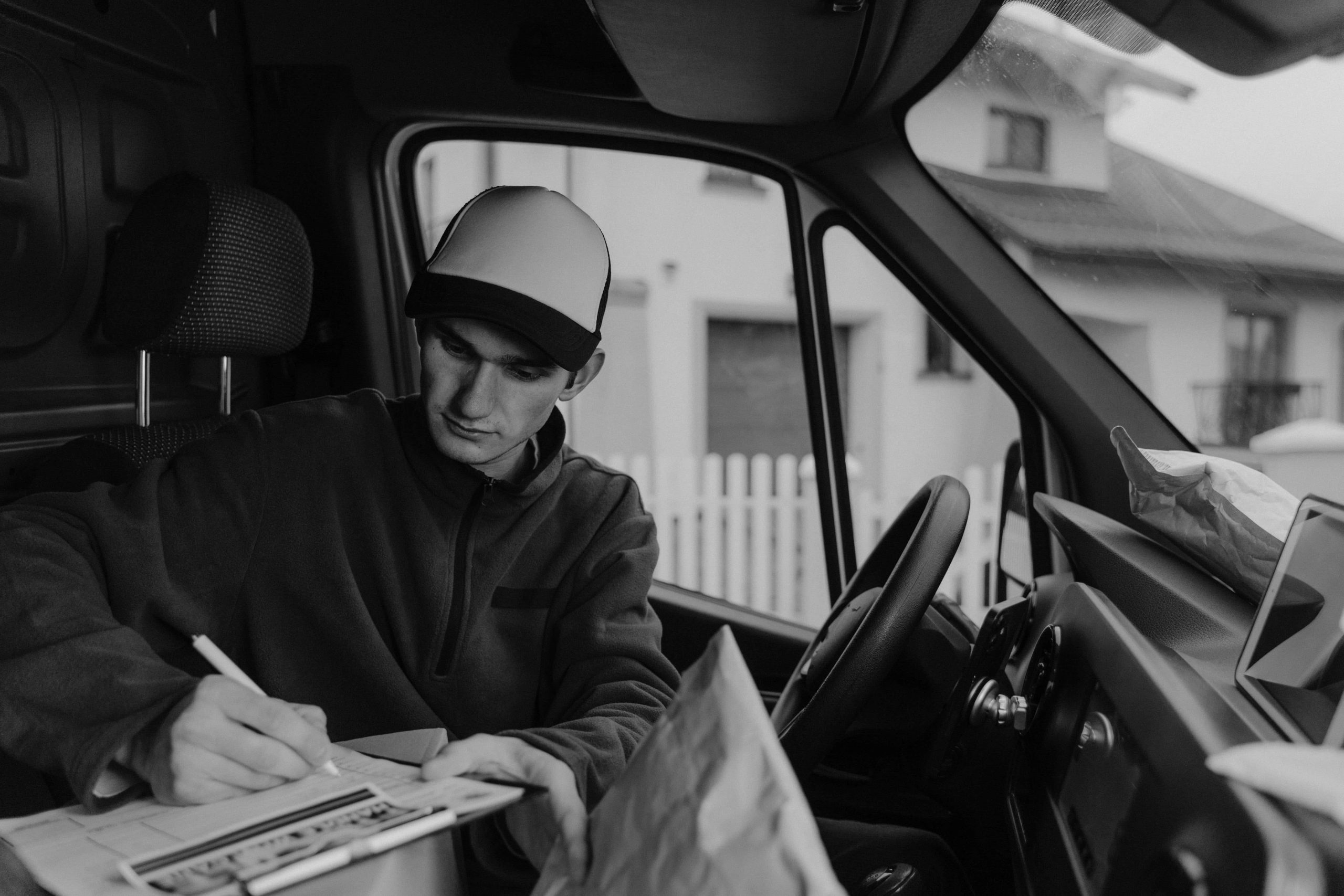 Delivery driver organizing packages in a van.